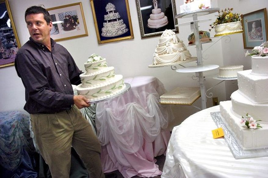 Creative Cakes owner Spencer Biles, carrying one of his creations into the Silver Spring company's display room, faces a daunting demand for cakes for Saturday, considered the most auspicious wedding date in decades.