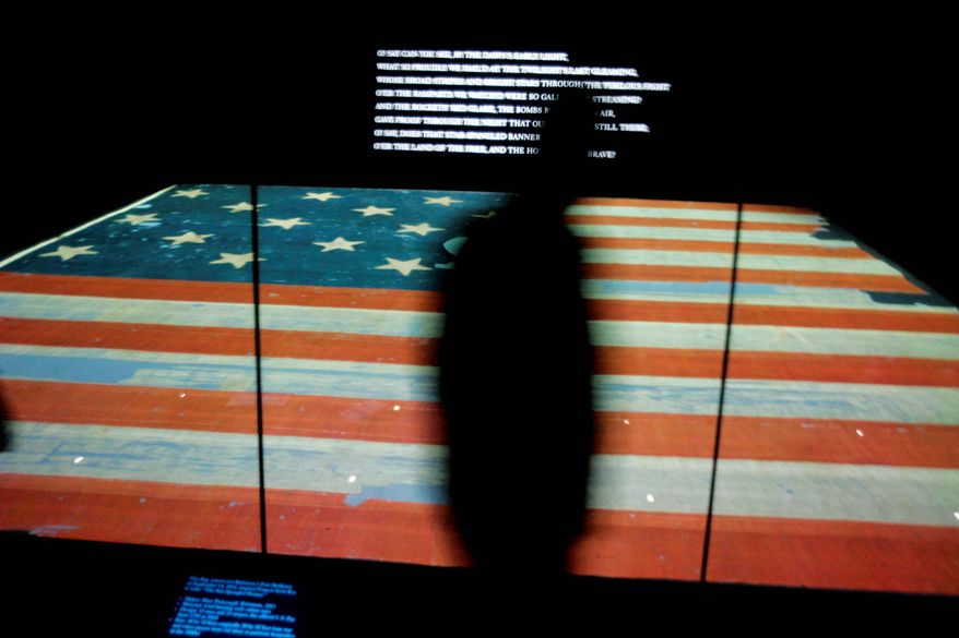 A museum visitor walks by the new Star-Spangled Banner exhibit, showcasing the nearly 200-year-old flag that inspired the writing of the song that became America's national anthem.
