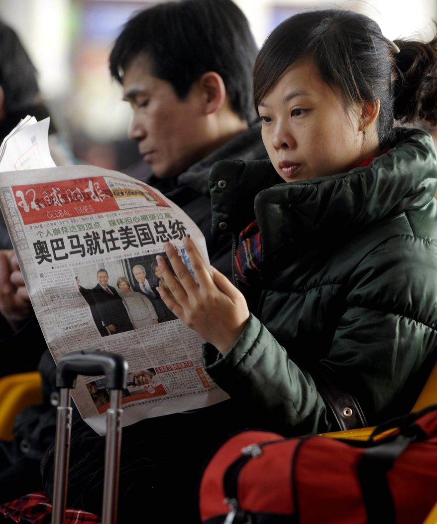 Agence France-Presse/Getty Images
A woman reading a newspaper on Wednesday in Beijing will not find President Obama's entire speech; the state news agency cut a reference to facing down "fascism and communism."