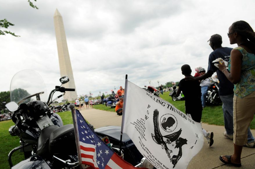 Isaac Katongole, 8; his father, Meddie Katongole; and Mr. Katongole's fiancee, Mercy Mbogori, make their way past motorcycles on the Mall. Rolling Thunder, which unites many veterans of the Vietnam War, seeks to bring home POWs and MIAs.