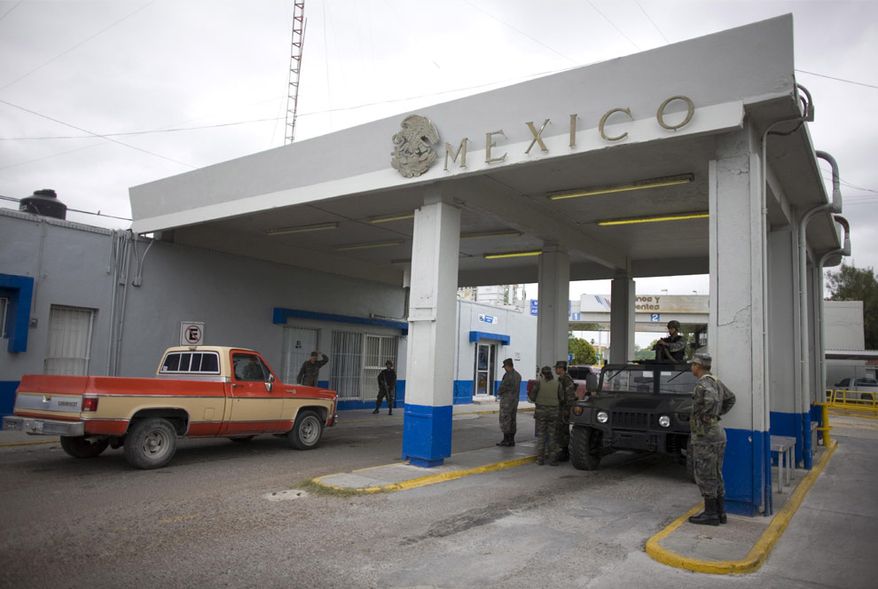 Mexican soldiers check cars at the customs checkpoint in Miguel Aleman, on Mexico's northeastern border with the U.S., Wednesday, March 18, 2009. (AP Photo/Alexandre Meneghini)