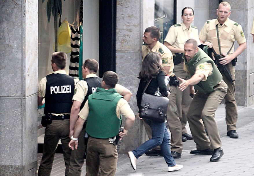 Police officers outside an H&M fashion store in central Leipzig, Germany, secure pedestrians on Tuesday, June 15, 2010, as an armed man inside holds several hostages, who were released without injury several hours later. Police spokeswoman Uta Barthel told the Associated Press that a 41-year-old man was in custody and that authorities believe psychological problems led to the hostage-taking. She declined to say how many hostages were taken, but said all were being cared for by medical professionals. (AP Photo/ddp/Sebastian Willnow)