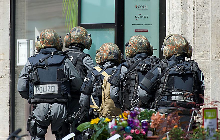 Police officers secure the exterior of an H&M fashion store in central Leipzig, Germany, on Tuesday, June 15, 2010, as an armed man inside holds several hostages, who were released without injury several hours later. Police spokeswoman Uta Barthel told the Associated Press that a 41-year-old man was in custody and that authorities believe psychological problems led to the hostage-taking. She declined to say how many hostages were taken, but said all were being cared for by medical professionals. (AP Photo/dapd/Eckehard Schulz)