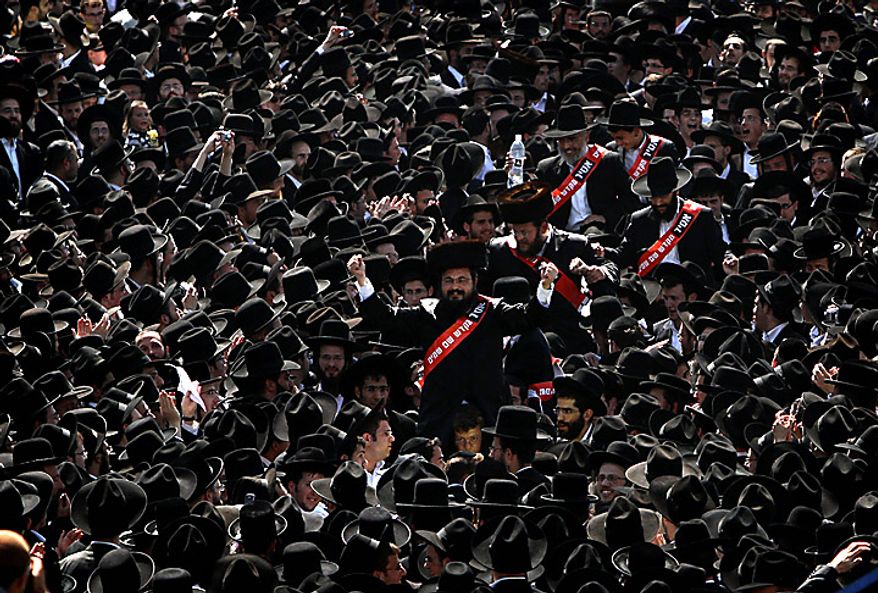 Ultra-Orthodox Jewish men escort parents (center) who oppose the integration of a religious girls school as they make their way to police headquarters in Jerusalem, where they are to be arrested on Thursday, June 17, 2010. Israel's Supreme Court ruled Sunday that the school must be integrated and ordered the dozens of parents, who have defied the integration efforts by keeping their daughters from school, to be jailed for two weeks, a decision that brought mass demonstrations by the ultra-Orthodox community. (AP Photo/Tara Todras-Whitehill)