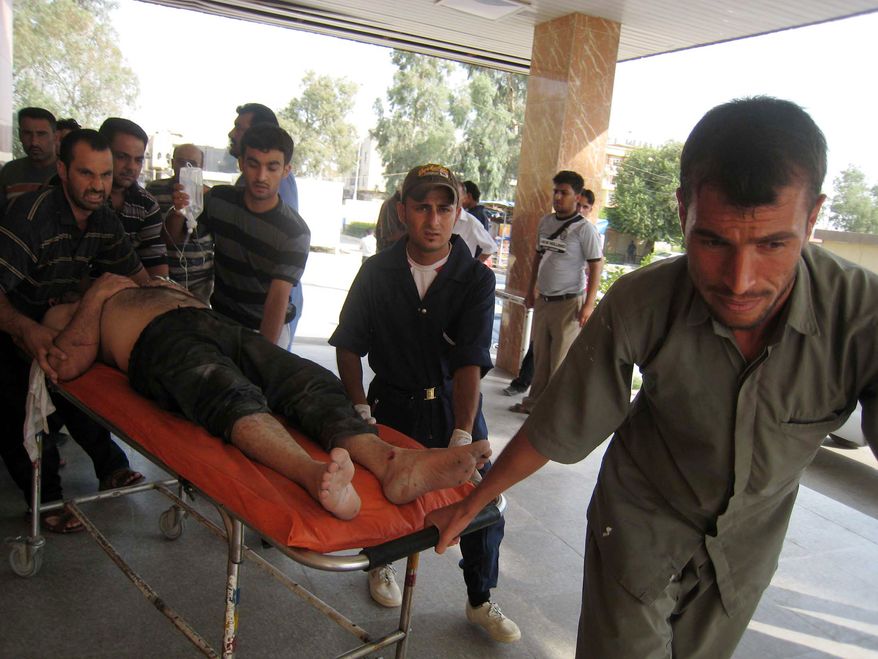 An injured man is rushed to a hospital after a car bombing in Tuz Khormato, in northern Iraq, Friday, June 18, 2010. Car bombs, meanwhile, tore through two neighborhoods in restive cities north of Baghdad in separate attacks targeting a police captain and a provincial council member. The deadliest attack was in the northern city of Tuz Khormato when an explosives-laden car blew up about 50 yards (meters) from the house of Niazi Mohammed, a Turkomen member of the Salahuddin provincial council, according to police. (AP Photo/Emad Matti)