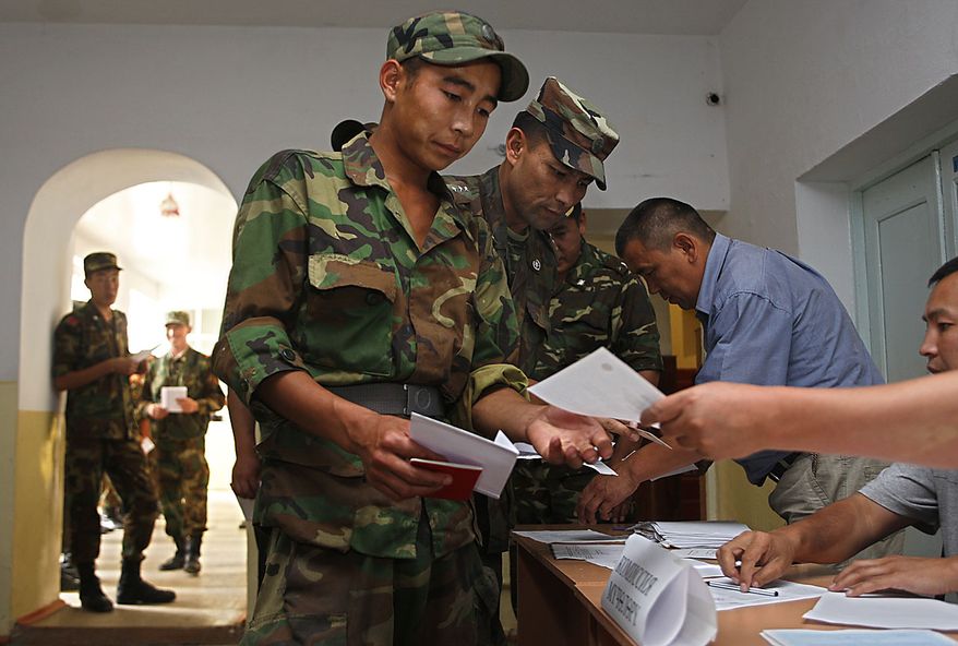 Kyrgyz soldiers receive their ballot papers at a polling station as early voting is held for Sunday's referendum in the southern Kyrgyz city of Osh, Kyrgyzstan, Friday, June 25, 2010. Kyrgyz authorities say they have arrested a nephew of deposed President Kurmanbek Bakiyev whom they accuse of playing a key role in organizing the ethnic rioting that killed hundreds of people. This month's unrest tore apart the Central Asian nation's south, with Kyrgyz rampaging through Uzbek neighborhoods. As many as 400,000 people fled their homes.(AP Photo/Sergei Grits)