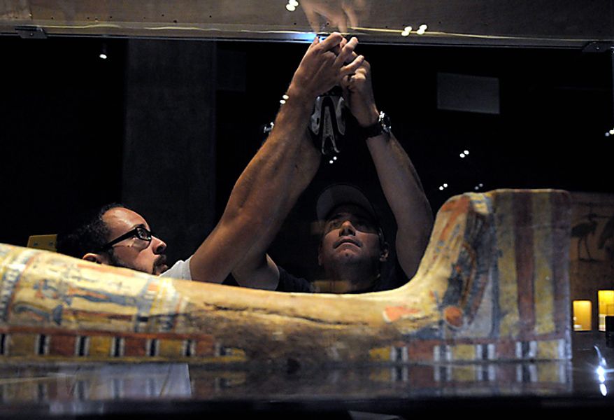 In this June 28, 2010 photo, Eric Rossi and John Diloszycki close the case on an Egyptian sarcophagus and mummy in Los Angeles in preparation for the opening of the new Mummies of the World exhibit at the California Science Center. The 45 mummies and 95 artifacts in the show come from 15 museums in seven countries, said Marc Corwin, CEO of American Exhibitions Inc. The show opens Thursday at the California Science Center, then will go on a three-year tour across the country. (AP Photo/Adam Lau)