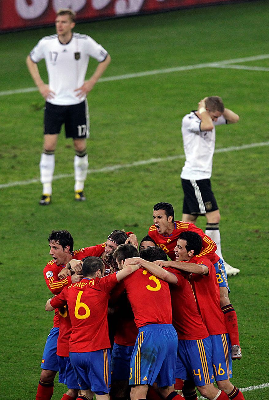 Spain's Carles Puyol is hidden by celebrating teammates after scoring their first goal during the World Cup semifinal soccer match between Germany and Spain at the stadium in Durban, South Africa, Wednesday, July 7, 2010. (AP Photo/Hassan Ammar)