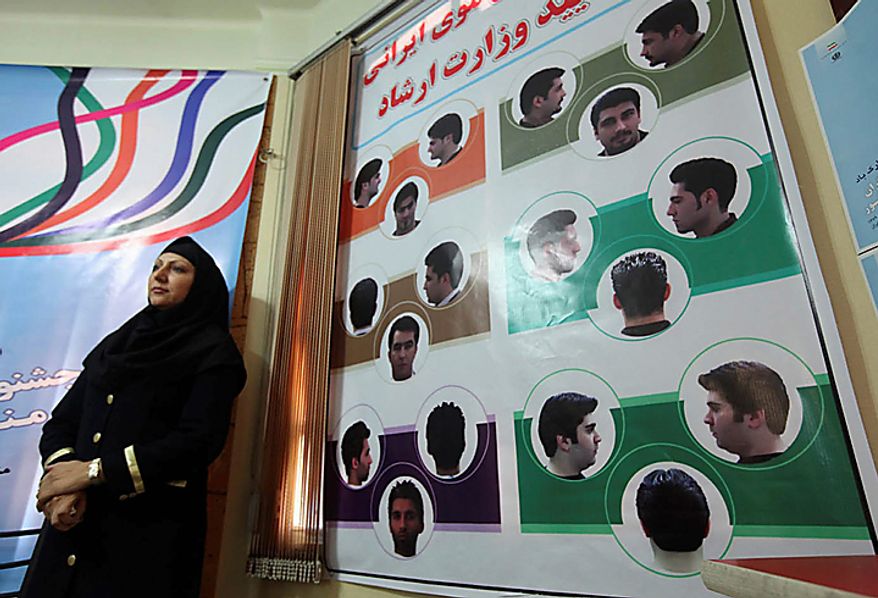 In this picture released by the semi-official Iranian Mehr News Agency, an Iranian woman stands next to a board of pictures of haircuts for men culturally appropriated by the Iran's Ministry of Culture and Islamic Guidance, in Tehran, Iran, on Monday, July 5, 2010. An Iranian fashion organization has issued a new list of culturally appropriate haircuts for men, possibly indicating a new crackdown on male attire after years of strict rules for women, Iranian media reported. (AP Photo/Mehr News Agency, Mohsen Rezaei/HO)