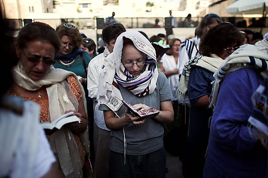 Israeli and international members of the Women of the Wall organization pray at the Western Wall, Judaism's holiest site, in Jerusalem's Old City, Monday, July 12, 2010. Anat Hoffman, the chairwoman for the Women of the Wall, was arrested for carrying a biblical scroll at a Judaism's holiest site on Monday in contravention of an Israeli high court ruling that bars women from carrying the holy texts in the area of the Western Wall, said police spokesman Micky Rosenfeld. (AP Photo/Tara Todras-Whitehill)