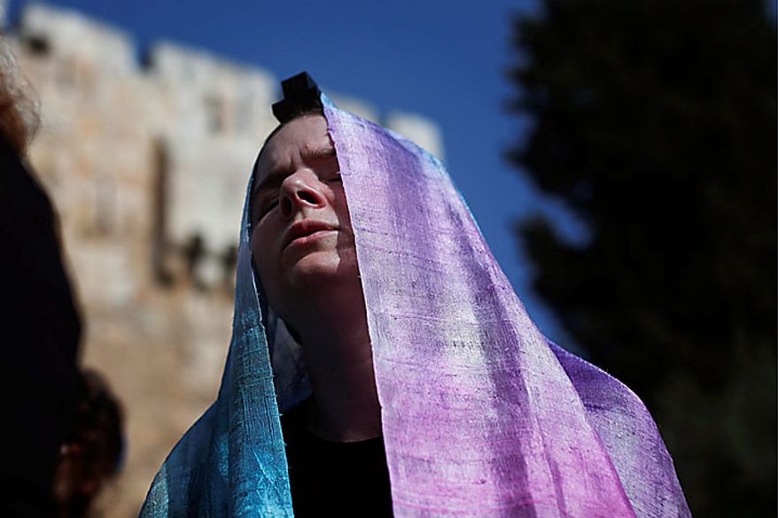 An Israeli member of the Women of the Wall organization prays outside a police station after Anat Hoffman, not pictured, the chairwoman for their organization, was detained outside the Western Wall, Judaism's holiest site, in Jerusalem's Old City, Monday, July 12, 2010. Ms. Hoffman was arrested for carrying a biblical scroll at a Judaism's holiest site on Monday in contravention of an Israeli high court ruling that bars women from carrying the holy texts in the area of the Western Wall, said police spokesman Micky Rosenfeld. (AP Photo/Tara Todras-Whitehill)