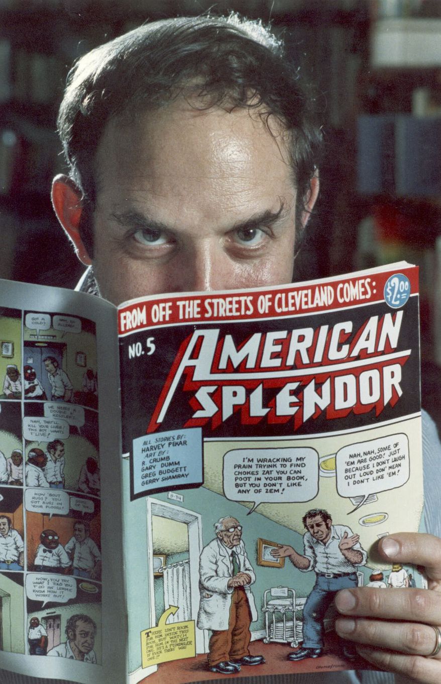 In this 1986 file photo comic-book writer Harvey Pekar poses with a copy of his "American Splendor" in his Cleveland Heights, Ohio home. (AP Photo/Mark Duncan, File)