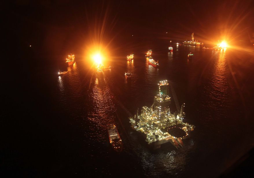 Vessels operate in the area of the Deepwater Horizon disaster on the Gulf of Mexico, Tuesday, July 13, 2010. BP officials have placed a containment cap over the leak in hopes that the flow of oil will be diminished. (AP Photo/Dave Martin)