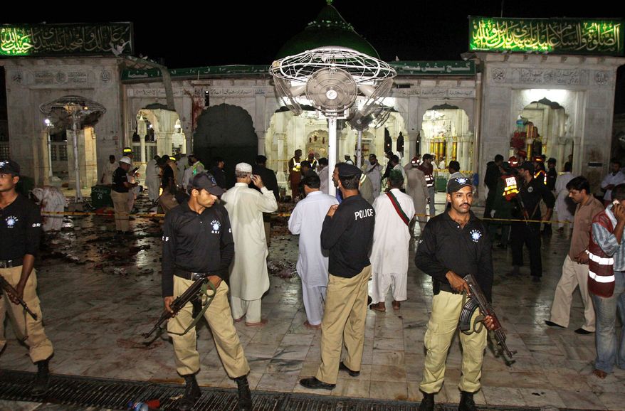 Pakistani police officers guard the area where suicide bombers attacked a sacred Muslim shrine in Lahore on July 1, killing 45 people. The attacks on shrines has exposed a rift between Pakistan's two largest Islamic sects. (Associated Press)