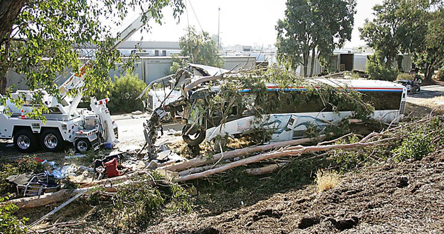 A crane begins to pull a Greyhound Bus that crashed and killed at least six people and injured many others on Thursday, July 22, 2010 in Fresno, Calif. (AP Photo/Gary Kazanjian)
