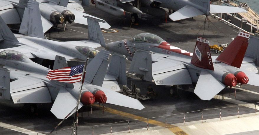 A U.S. navy personnel takes a rest under the wings of a fighter jet plane on the deck of U.S. nuclear-powered aircraft carrier USS George Washington at the Busan port in Busan, south of Seoul, South Korea, Saturday, July 24, 2010. North Korea warned Saturday that joint U.S. and South Korean military exercises poised to begin this weekend amount to a military provocation that will draw a "powerful" nuclear response from Pyongyang. (AP Photo/Lee Jin-man)