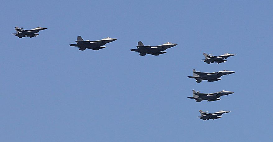 U.S. F-22 stealth fighters, second and third from left, fly with other fighters over the Nimitz-class USS George Washington during joint military exercises between the U.S. and South Korea in South Korea's East Sea on Monday, July 26, 2010. U.S. and South Korean warships and helicopters practiced anti-submarine maneuvers off the Korean Peninsula Monday that officers said they hope would serve as a warning to Pyongyang that aggression in the region would not be tolerated. (AP Photo/ Lee Jin-man, Pool)