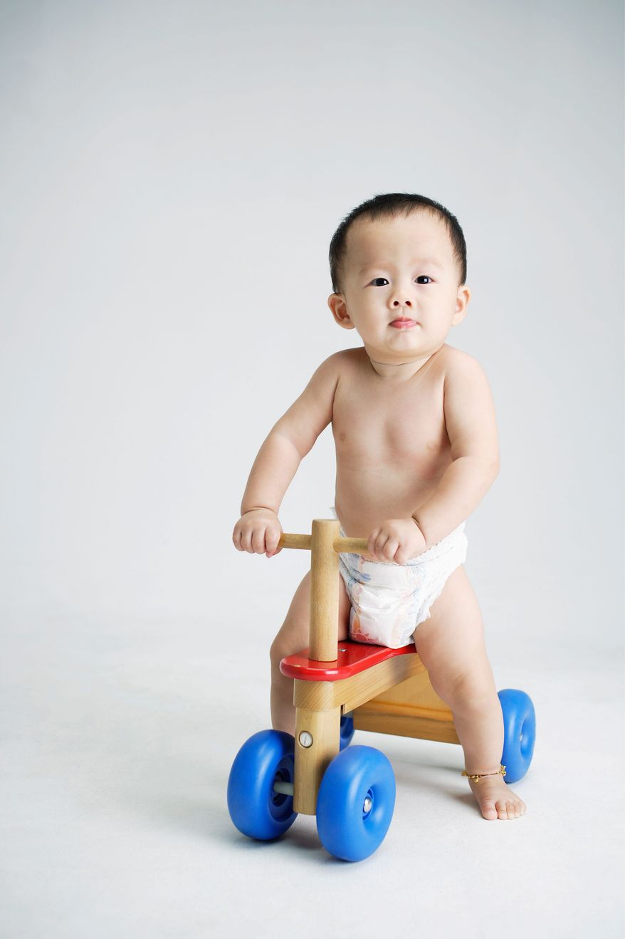 Baby on toy bike (OJO Images via AP Images)