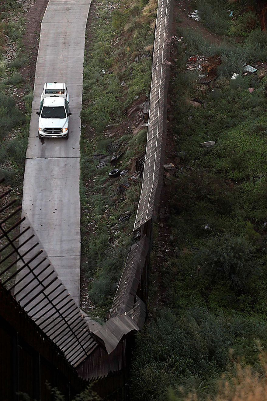 A Border Patrol vehicle sits along the border fence separating Nogales, Ariz., and Nogales, Sonora, Mexico, Wednesday, July 28, 2010. Arizona's new immigration law SB1070 takes effect Thursday, July 29. (AP Photo/Jae C. Hong)