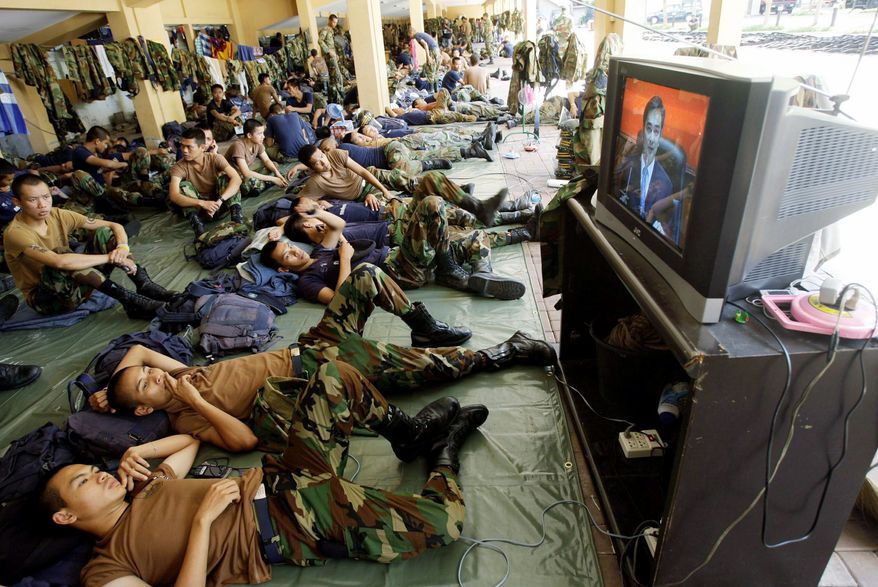 Soldiers watch Mr. Abhisit's April 12, 2009, speech from Government House in Bangkok announcing a state of emergency aimed at stemming anti-government protests across the country.