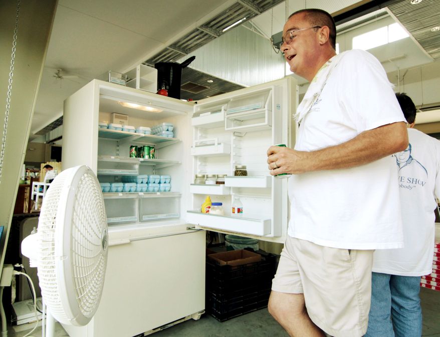 ASSOCIATED PRESS
Bob Stoltzfus cools down with a fan and cool air escaping from a refrigerator while taking inventory of his egg supply at the Mississippi Farmers Market in Jackson, Miss., on Thursday.