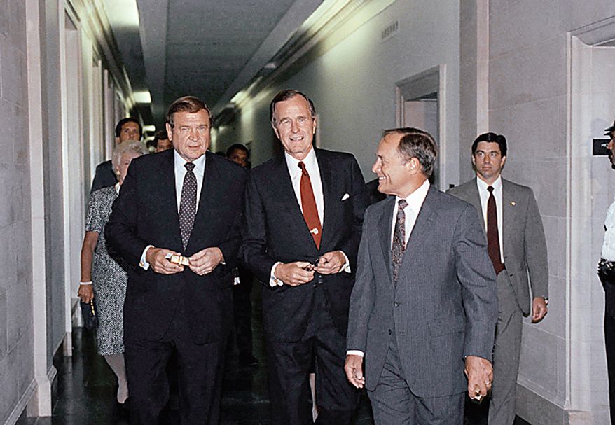 U.S. President George H. Bush waves to photographers as he walks with Reps. Dan Rostenkowski, D-Ill., chairman of the House Ways and Means Committee, left; and Bill Archer, R-Texas, ranking Republican on the same committee, right, on Capitol Hill in Washington, Monday, July 24, 1989. Bush attended the committee's Capitol Hill dinner. At far left is first lady Barbara Bush. (AP Photo/Ron Edmonds)