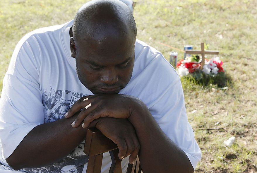 Anthony Cheathams Sr., mourns at the site where David Motley was killed in Flint, Mich., Thursday, Aug. 12, 2010. Elias Abuelazam, the suspect in a string of stabbings that terrorized people across three states and left five dead, was charged Thursday with assault with intent to murder in connection with a July 27 stabbing in Flint. Abuelazam was arrested at a gate at Hartsfield-Jackson Atlanta International Airport as he tried to board a plane for Israel, officials said Thursday. (AP Photo/Paul Sancya)