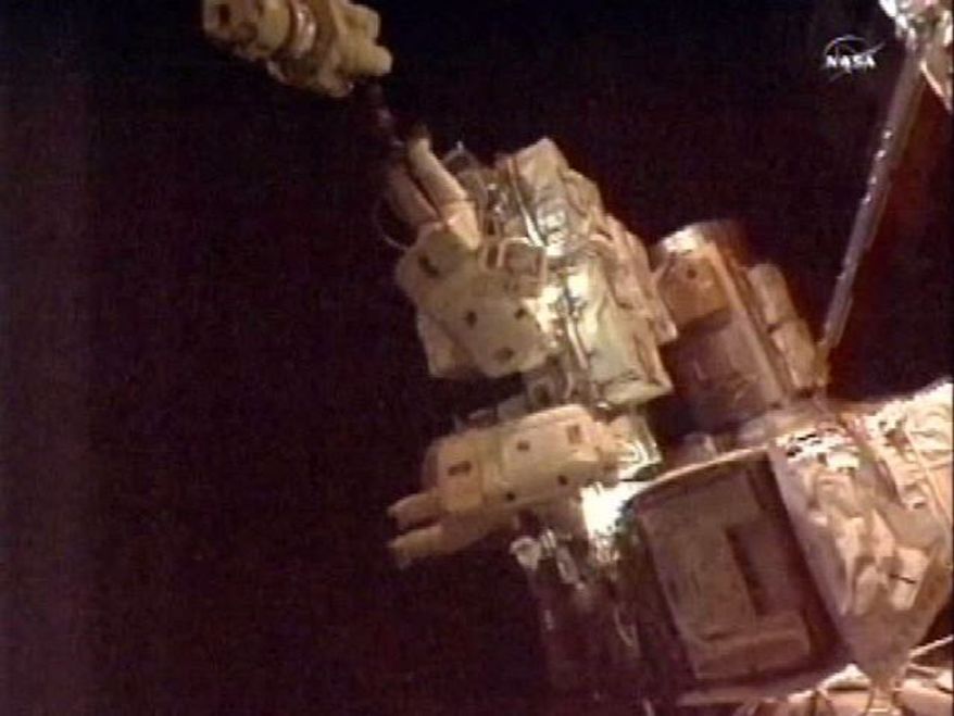 Expedition 24 astronauts Tracy Caldwell Dyson and Douglas Wheelock work outside the International Space Station on Monday, Aug. 16, 2010, as they prepare to install a cooling pump module, replacing one that failed. (AP Photo/NASA)