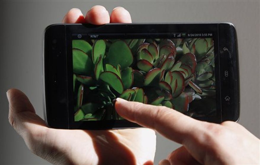 In this Aug. 24, 2010 photo, an Associated Press reporter holds the Dell Streak phone during a product review in San Francisco. (AP Photo/Jeff Chiu)