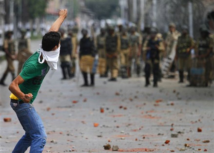 FILE - In this Wednesday, July 28, 2010 file photo, Kashmiri protesters throw stones on Indian policemen during a protest in Srinagar, India. Ahmed, who calls himself "an anonymous soldier of Kashmir's resistance movement," is part of a wave of Web savvy protesters in Kashmir who have begun using social networking sites to publicize their fight against Indian rule to a global audience and to keep other demonstrators energized and focused. (AP Photo/Mukhtar Khan, File)