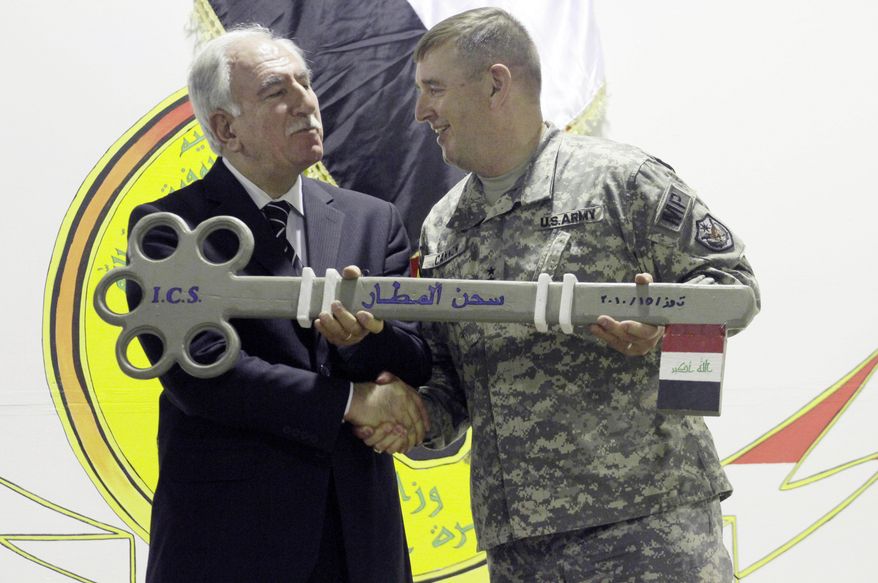 In this Thursday, July 15, 2010, file photo, Iraq's Minister of Justice Dara Noureddin, left, and U.S. Army Maj. Gen. Jerry Cannon, right, hold a symbolic key to the US Theater Internment Facility at Camp Cropper during a ceremony transferring the facility to Iraqi control in Baghdad, Iraq. U.S. and Iraqi officials say four prisoners with links to al Qaeda have escaped from the U.S.-controlled part of a prison in Baghdad. (AP Photo/Maya Alleruzzo, File)