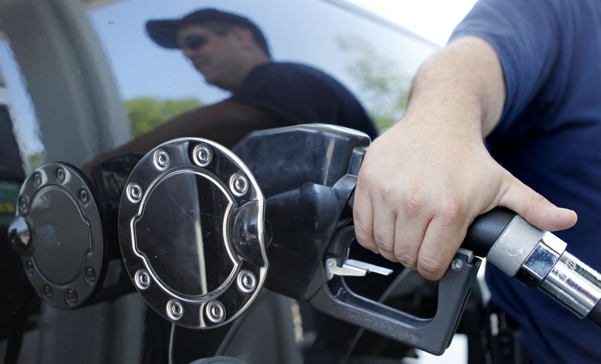 **FILE** In this May 26 photo, Kevin Stearns of Oxford, Mass., fills up his pick up truck at a gas station in Milford, Mass. (Associated Press)
