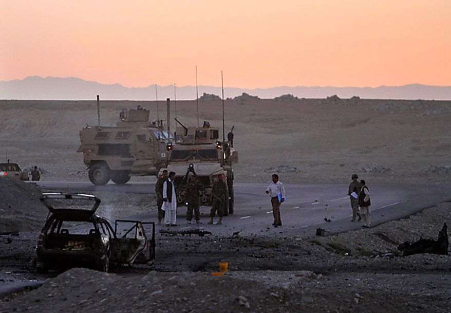 U.S soldiers inspect a site after a suicide car-bomb in Behsood district of Jalalabad, Afghanistan, Monday Sept. 20, 2010. The attack on a NATO convoy reportedly injured four Afghan civilians. (AP Photo/Rahmat Gul)