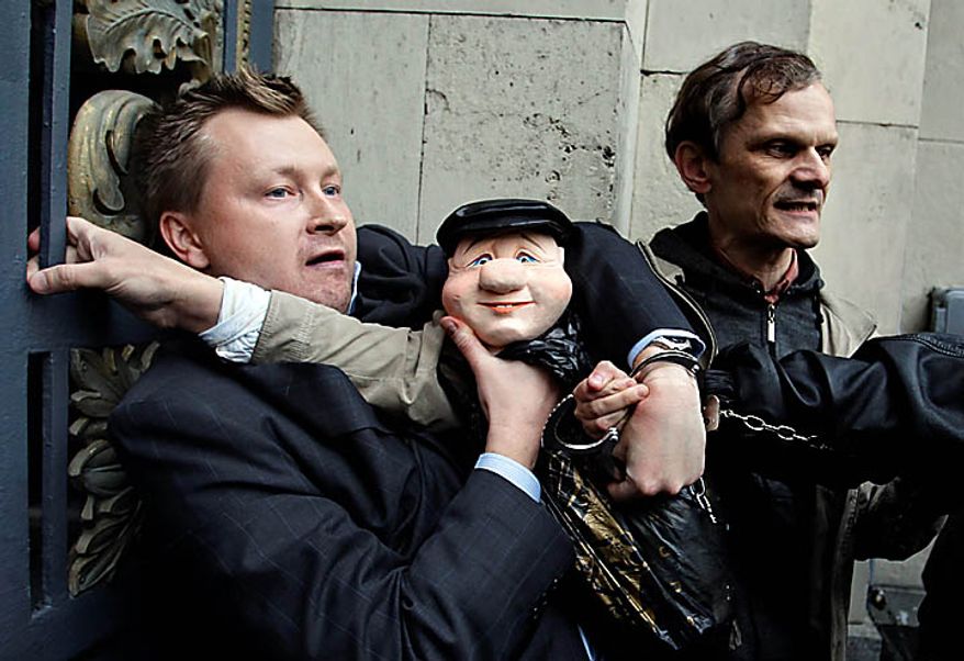 Police officers detain a russian gay rights activist Nikolai Alexeyev holding a puppet of Moscow Mayor Yuri Luzhkov during a rally near city hall in Moscow, Tuesday, Sept., 21, 2010. Moscow police has dispersed a gay rally and detained activists protesting homophobic policies of Moscow authorities. Mayor Yuri Luzhkov has called homosexuals "satanic" and routinely thwarted their attempts to hold a gay pride in Moscow. Police officers detained on Tuesday at least a dozen activists in a Moscow square near the city hall minutes after they brought out a papier-mache mummy that resembled Luzhkov and unfurled posters ridiculing him. (AP Photo/Sergey Ponomarev)