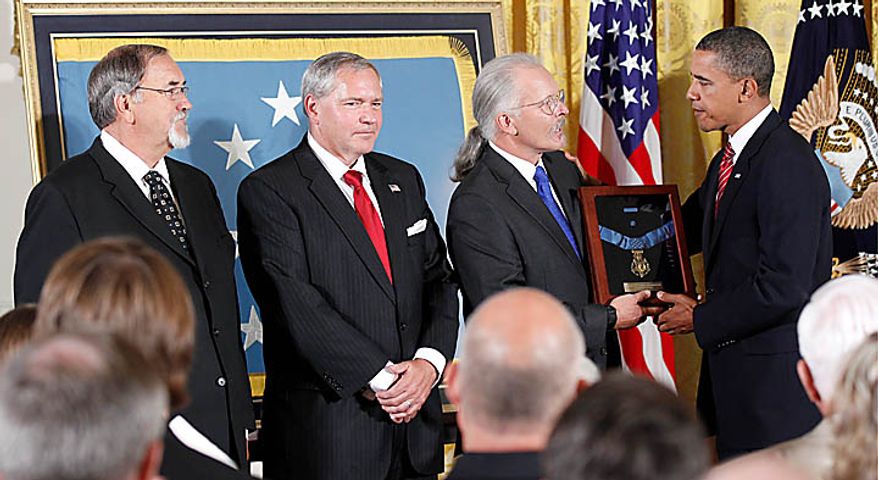 President Barack Obama presents the Medal of Honor posthumously to the sons of Air Force Chief Master Sgt. Richard L. Etchberger, right to left, Richard Etchberger Corey Etchberger, and Steve Wilson, during a ceremony in the East Room of the White House in Washington, Tuesday, Sept. 21, 2010. Etchberger received the honor for his heroic actions in combat in Laos on March 11, 1968, after deliberately exposing himself to enemy fire in order to put his wounded comrades in rescue slings permitting them to be airlifted to safety. (AP Photo/Pablo Martinez Monsivais)