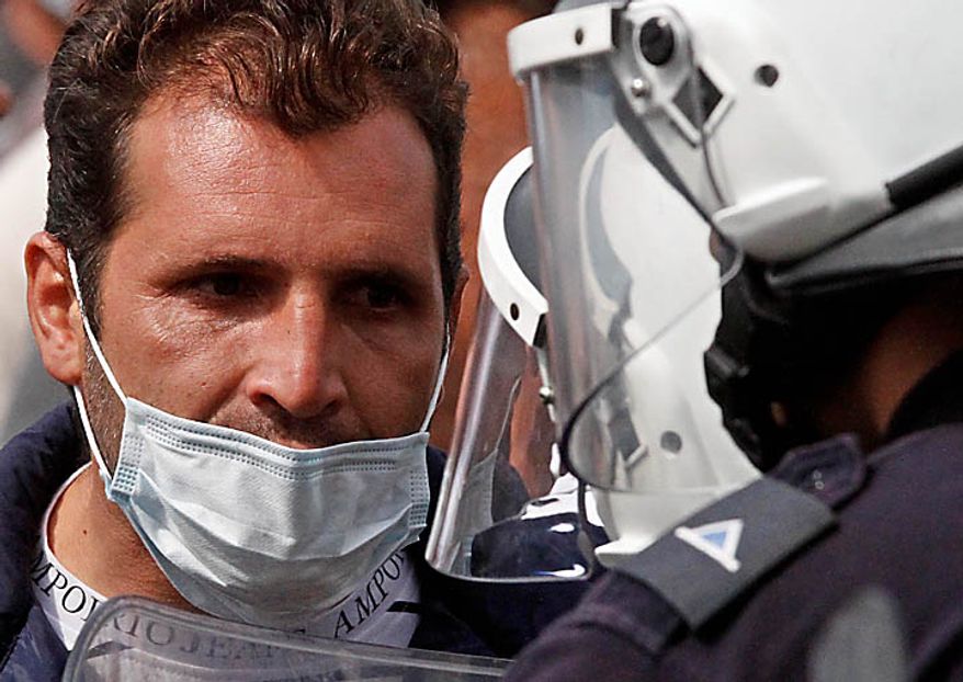 A truck driver argues with riot police outside the Greek Parliament in Athens, Wednesday, Sept. 22, 2010. Truckers strongly oppose government plans to reform their sector and abolish strict licensing rules. (AP Photo/Dimitri Messinis)