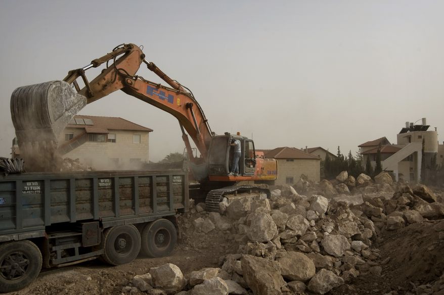 A bulldozer works at a construction site in the Jewish settlement of Adam outside Jerusalem on Sunday, Sept. 26, 2010. With a midnight deadline looming, Israeli Prime Minister Benjamin Netanyahu on Sunday called on West Bank settlers to "show restraint" after the end of a government-ordered construction slowdown, attempting to lower tensions with the Palestinians and prevent a breakdown in newly relaunched Mideast talks. (AP Photo/Sebastian Scheiner)