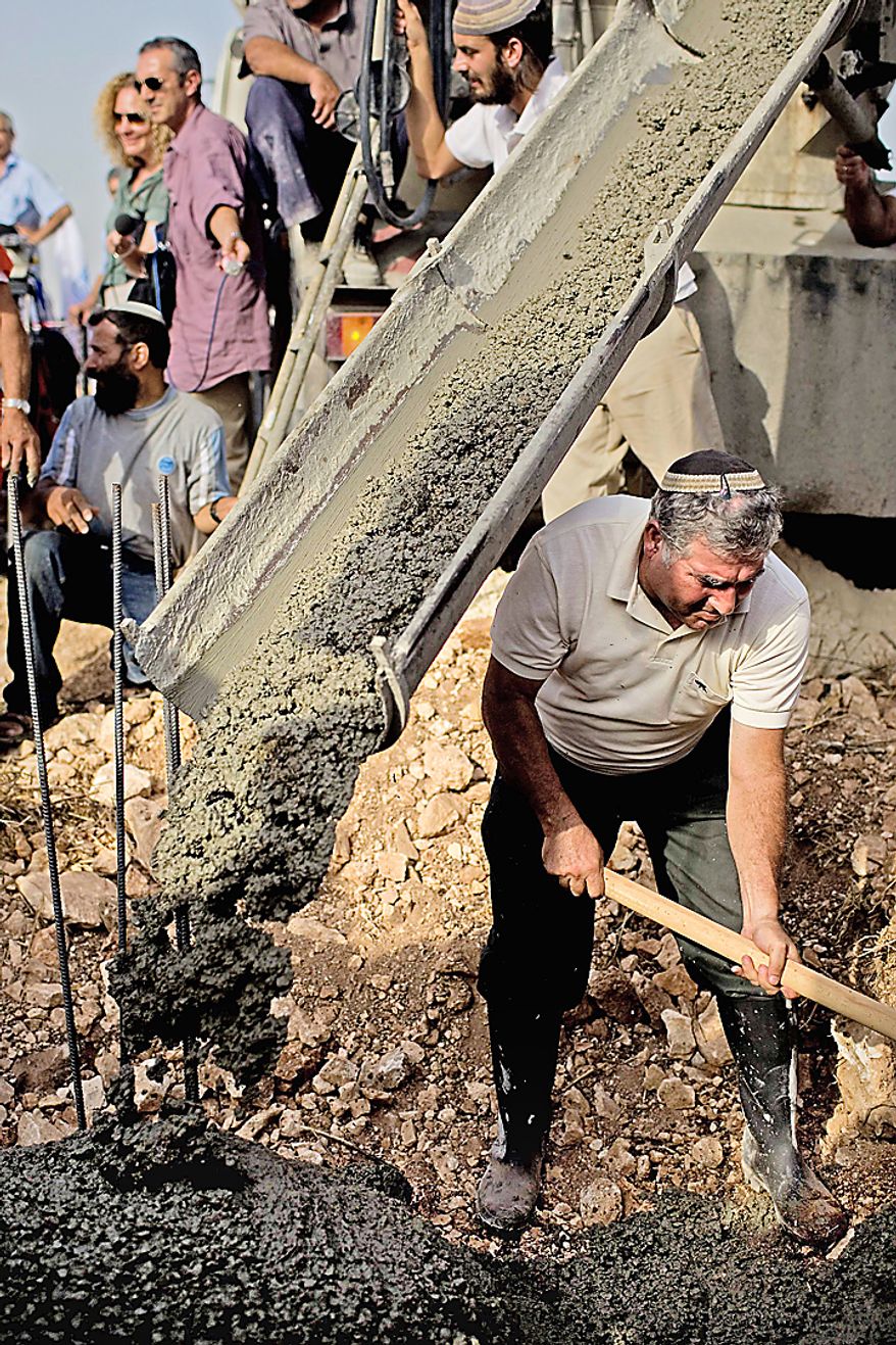 Jewish settlers participate in a cornerstone laying ceremony for a daycare center at the West Bank Jewish settlement of Kiryat Netafim, Sunday, Sept. 26, 2010. With a midnight deadline looming, Israel's prime minister on Sunday called on West Bank settlers to "show restraint" after the end of a government-ordered construction slowdown, attempting to lower tensions with the Palestinians and prevent a breakdown in newly re-launched Mideast talks. (AP Photo/Ariel Schalit)