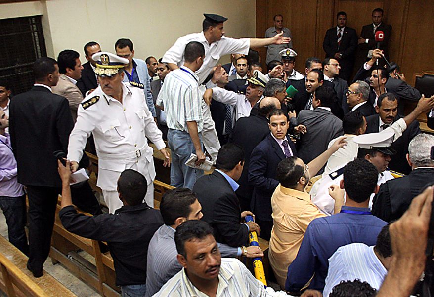 Egyptian policemen restore order, Tuesday, Sept. 28, 2010 after the verdict on Hisham Talaat Moustafa, an Egyptian real estate mogul and lawmaker, at a court in Cairo, Egypt. In a case which has captivated the Arab public, the court has handed billionaire tycoon Hisham Talaat Moustafa a lighter sentence of just 15 years after an earlier trial sentenced him to death for paying a retired Egyptian police officer to kill his pop star lover, Lebanese singer Suzanne Tamim. (AP Photo/Maher Malak)