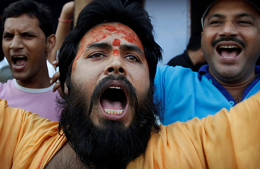 A Hindu priest shouts slogans as he celebrates after hearing the first reports on the court verdict in Ayodhya, India, Thursday, Sept. 30, 2010. An Indian court ruled Thursday that a disputed holy site that has sparked bloody communal riots across the country in the past should be divided between the Hindu and Muslim communities. However, the court gave the Hindu community control over the section where the now demolished Babri Mosque stood and where a small makeshift tent-shrine to the Hindu god Rama rests. While both Muslim and Hindu lawyers vowed to appeal to the Supreme Court, the compromise ruling seemed unlikely to set off a new round of violence, as the government had feared. (AP Photo/Rajesh Kumar Singh)