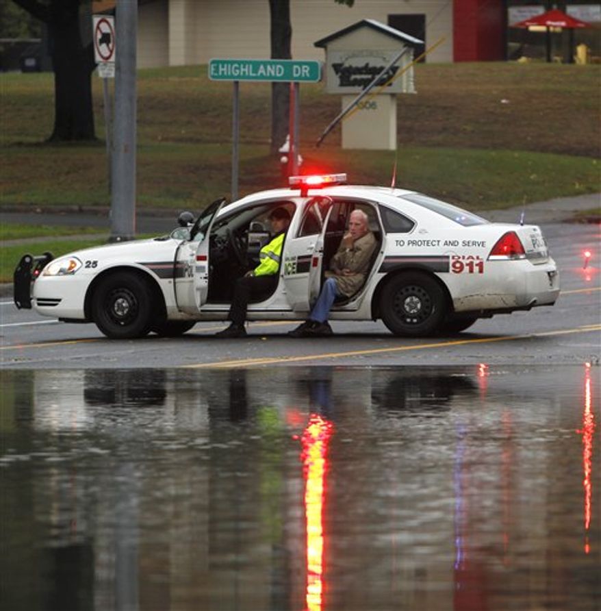 A man sits in a police vehicle after walking from his car that was stranded on a flooded road in Guilderland, N.Y., Friday, Oct. 1, 2010. (AP Photo/Mike Groll)