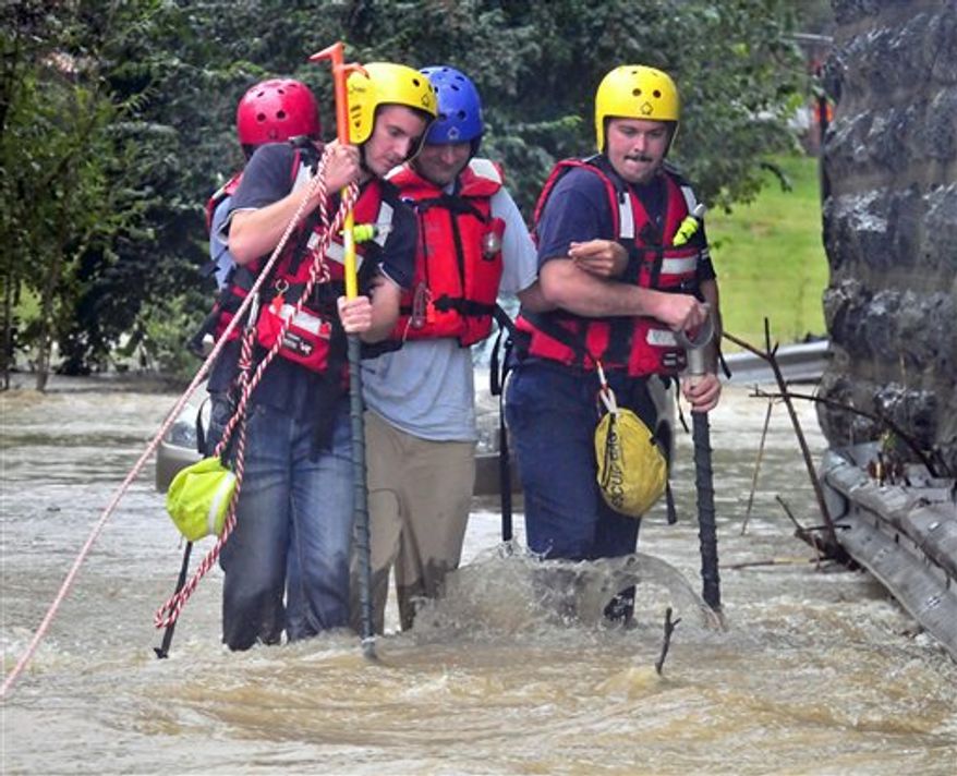 East Petersburg Fire Company firefighters walk a motorist through high water after his car became stranded in the Little Conestoga Creek, Thursday, Sept. 30, 2010 in Lancaster, Pa, Much of eastern Pennsylvania is under flood warnings as storms could bring as much as six inches of rain before leaving the area on Friday. The National Weather Service issued a tornado watch Thursday for counties stretching from Philadelphia west to York and north to Allentown. (AP Photo/Intelligencer Journal, Blaine Shahan)