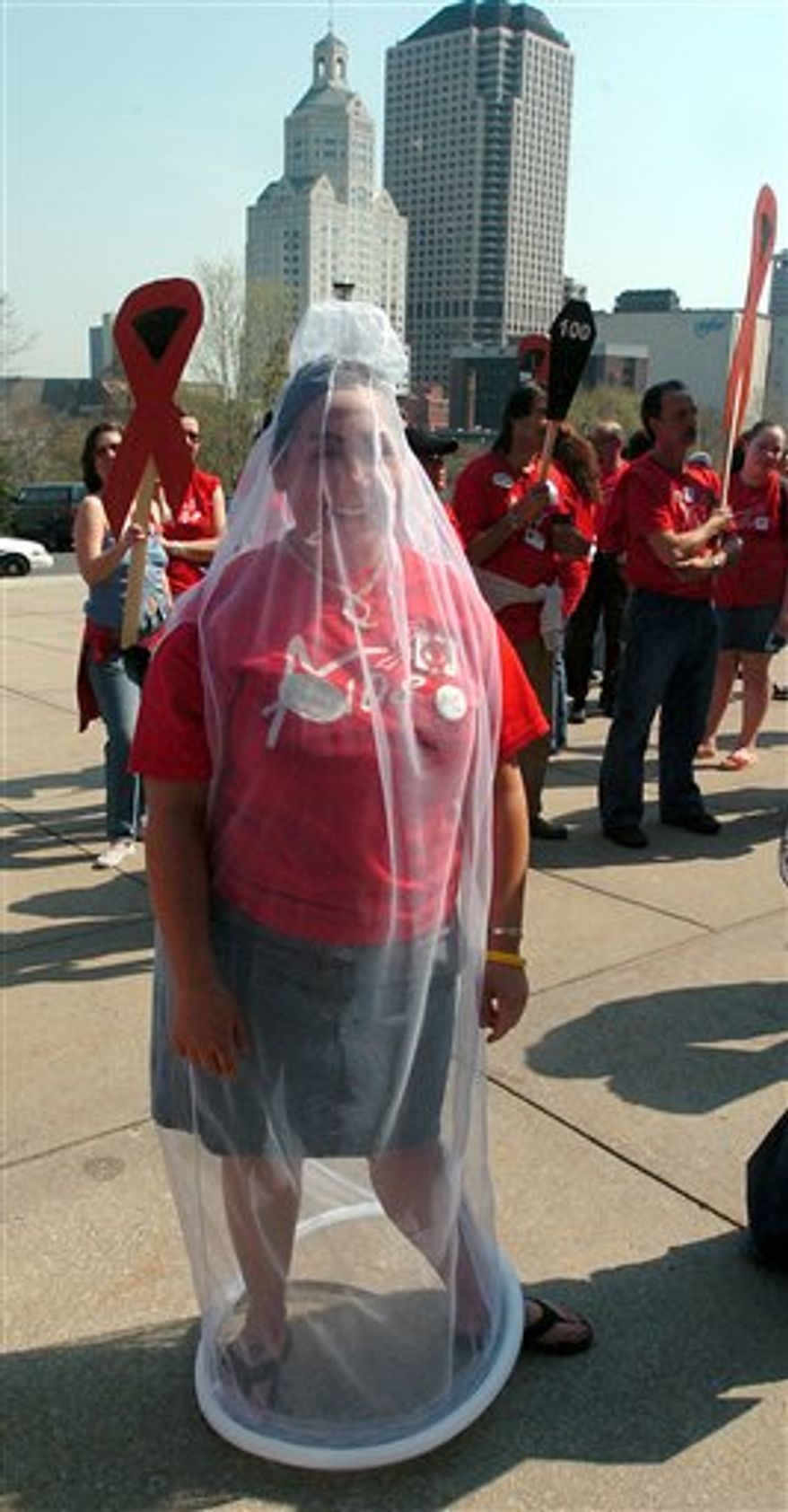 FILE - In this April 20, 2005 file photo, student Marissa Manzi wears a condom costume at an AIDS Awareness Day rally outside the state Capitol in Hartford, Conn. The male-female orgasm gap. The sex lives of 14-year-olds. An intriguing breakdown of condom usage rates, by age and ethnicity, with teens emerging as more safe-sex-conscious than boomers. That's just a tiny sampling of the data being unveiled Monday, Oct. 4, 2010 in what the researchers say is the largest, most comprehensive national survey of Americans' sexual behavior since 1994. (AP Photo/Bob Child, File)
