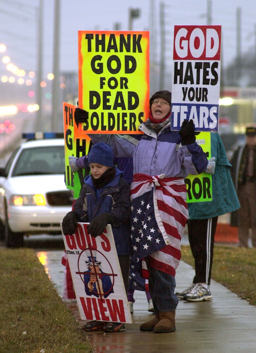 In this Feb. 8, 2006, file photo, Margie Phelps, right, and her nephew, Gabriel Phelps-Roper, then 10, center, both from the Westboro Baptist Church in Topeka, Kan., protest before the start of a memorial service for soldiers killed in combat from the Army's 101st Airborne Division in front of the main entrance to Fort Campbell, Ky. Ms. Phelps is set to go before the U.S. Supreme Court on Wednesday, Oct. 5, 2010, to represent her church in a case that tests the scope of free speech protections under the Constitution's First Amendment. (AP Photo/Christopher Berkey, File)