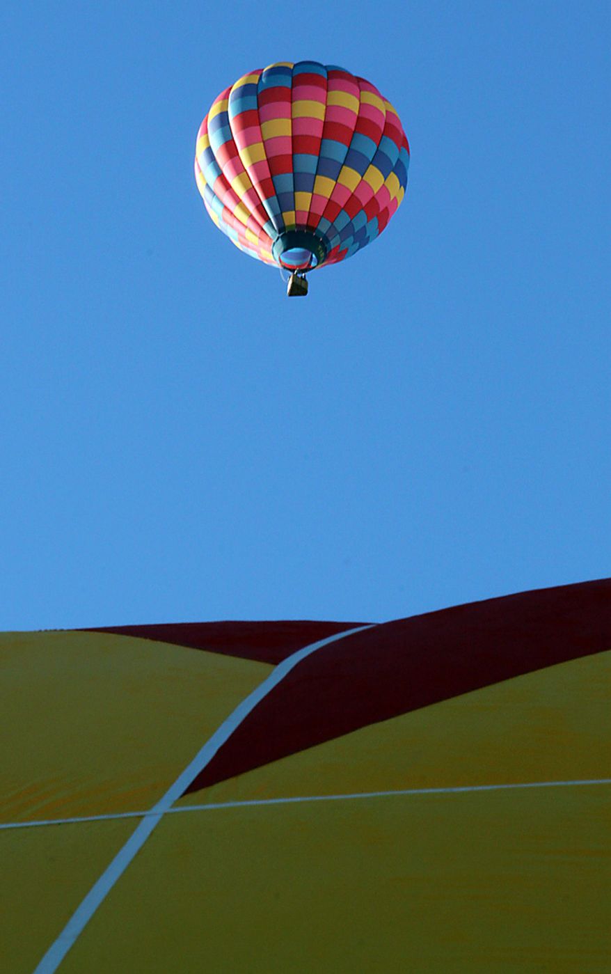 A hot air balloon lifts off during the Albuquerque International Balloon Fiesta in Albuquerque, N.M., on Tuesday, Oct. 5, 2010. The annual event has attracted about 500 balloons and thousands of spectators. (AP Photo/Susan Montoya Bryan)