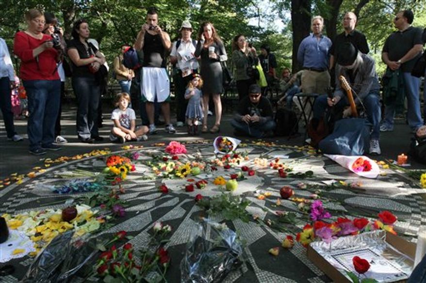 People gather around the Imagine mosaic in Strawberry Fields in New York's Central Park, Saturday, Oct. 9, 2010. This would have been John Lennon's 70th birthday. (AP Photo/Tina Fineberg)