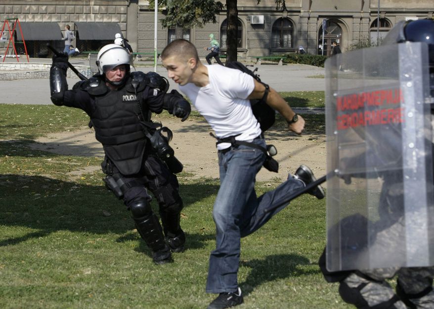Police attempt to detain a man during anti-gay riots intended to disrupt a gay pride march in Belgrade, Serbia, on Sunday, Oct. 10, 2010. (AP Photo/Darko Vojinovic)