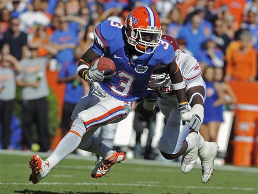FILE - In this Oct. 17, 2009, file photo, Florida's Chris Rainey (3) gains yardage as he is chased by Arkansas defensive end Tenarius Wright during the first half of an NCAA college football game in Gainesville, Fla. Florida receiver Chris Rainey, suspended last month after being charged with aggravated stalking, is back and could play again this season. Coach Urban Meyer said in a statement Tuesday, Oct. 12, 2010, that Rainey has returned to practice. Meyer said Rainey won't play Saturday night against Mississippi State but left open the possibility that Rainey could be back on the field against Georgia on Oct. 30. (AP Photo/Phil Sandlin, File)