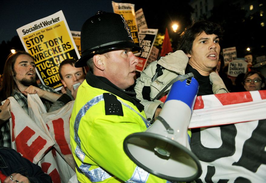Protesters clash with police during a rally in London against spending cuts on Wednesday. Britain will slash benefits and jobs to make the largest cuts to public spending since World War II. (Associated Press)
