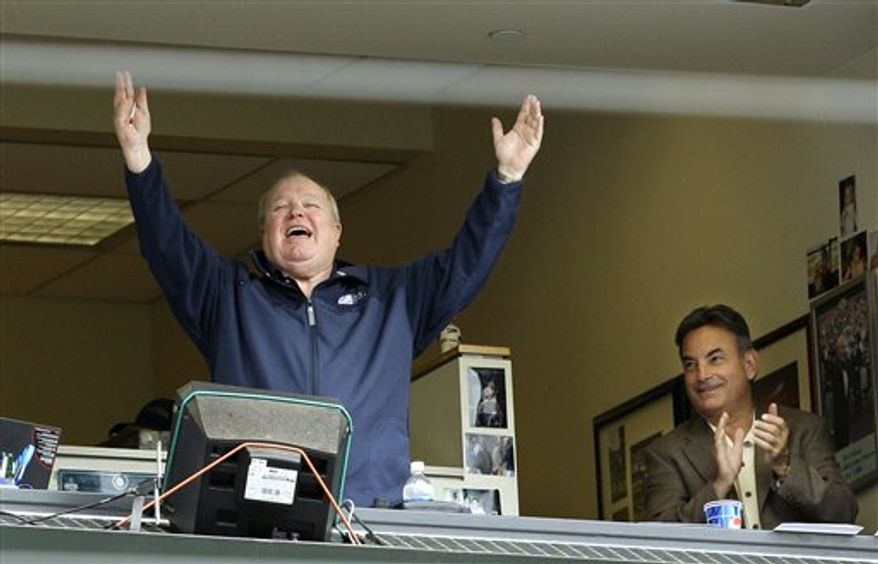FILE - In this July 23, 2008, file photo, broadcaster Dave Niehaus raises his arms in the booth as he is introduced to the crowd during a baseball game between the Seattle Mariners and the Boston Red Sox, as fellow broadcaster Rick Rizzs applauds at right in Seattle. Niehaus, the legendary and beloved voice of the Mariners from their inception in 1977 through the final game of the 2010 season, has died, the ballclub confirmed on Wednesday, Nov. 10, 2010. Niehaus, who received the Ford Frick Award at the Hall of Fame induction ceremony in 2008, was 75. (AP Photo/Elaine Thompson, File)